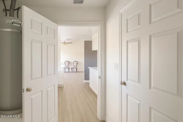 a view of a hallway with wooden floor and closet area