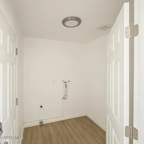 a view of a room with wooden floor and white walls