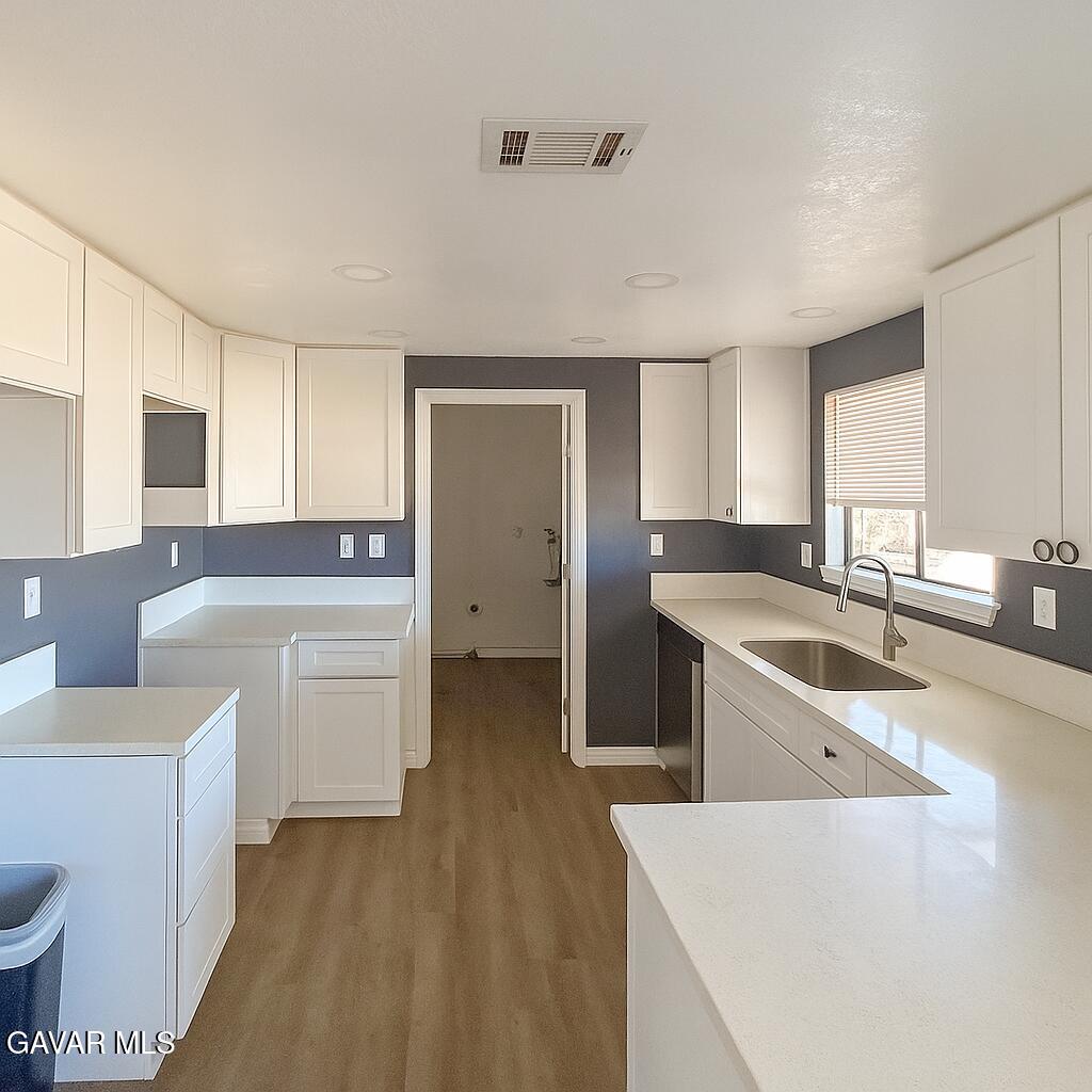 16549 Mossdale Avenue Lake Los Angeles, CA 93535 - Photo 5 of 23 a large kitchen with a lot of counter space and wooden floor