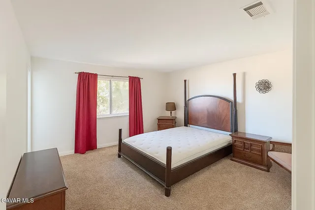 a bedroom with a bed and a large mirror