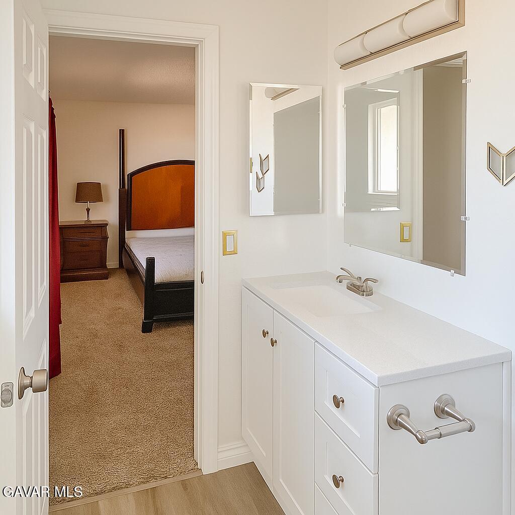 16549 Mossdale Avenue Lake Los Angeles, CA 93535 - Photo 9 of 23 a en suite bathroom with a sink and a mirror