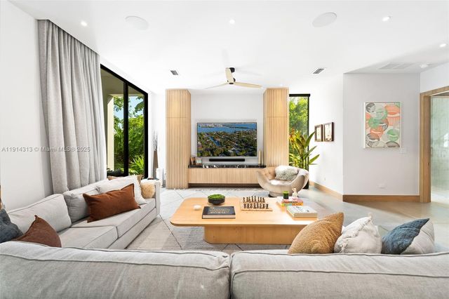 a living room with furniture and large windows