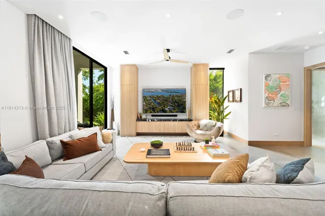 a living room with furniture and large windows