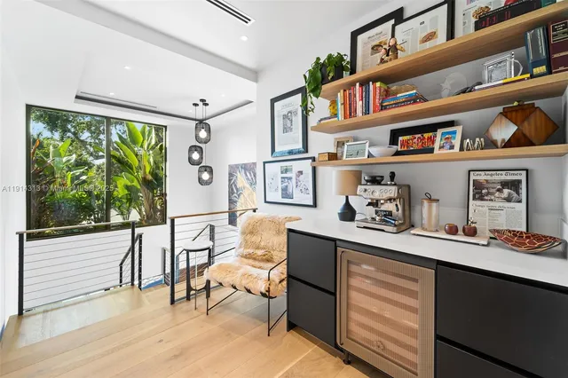 a living room with furniture book shelf and a large window