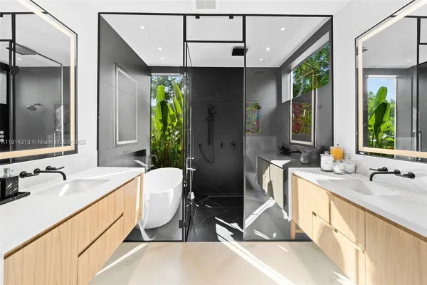 a spacious bathroom with a double vanity sink a mirror and a bathtub