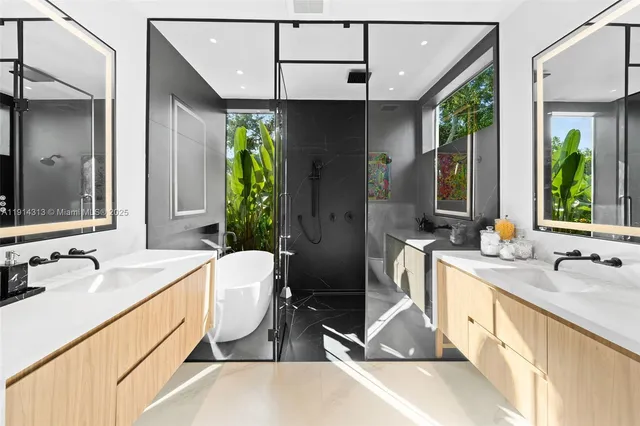 a spacious bathroom with a double vanity sink a mirror and a bathtub
