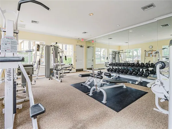 a gym room with lots of chairs and mirrors
