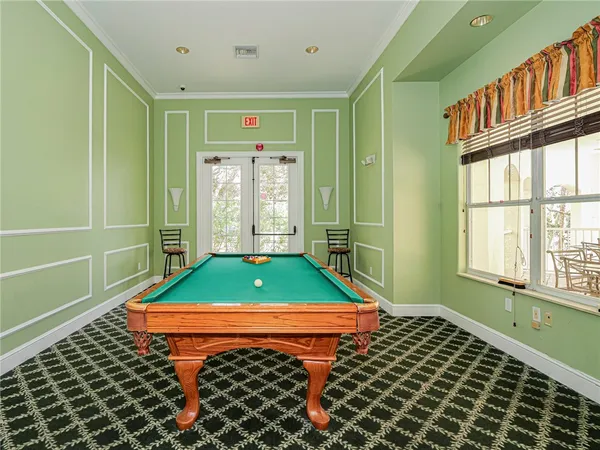 a room with pool table and windows