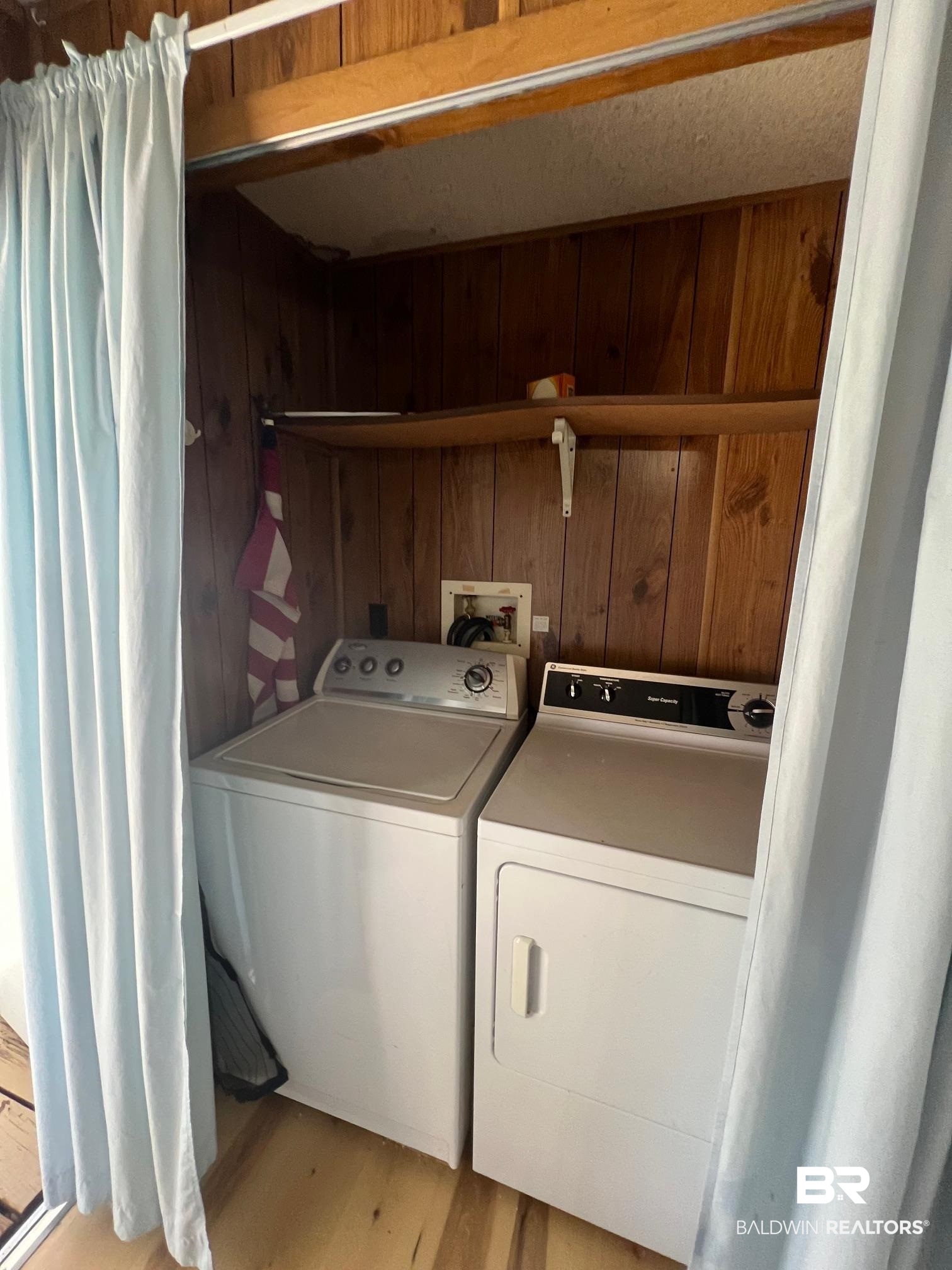 1332 Ridgewood Drive Lillian, AL 36549 - Photo 9 of 32 Washroom with separate washer and dryer, wooden walls, and hardwood / wood-style flooring