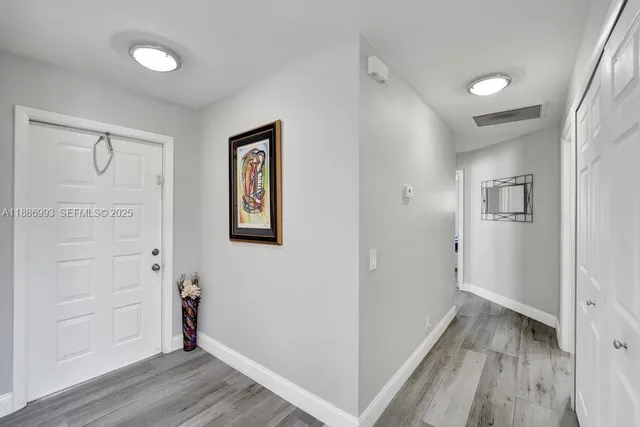 a view of a hallway with wooden floor