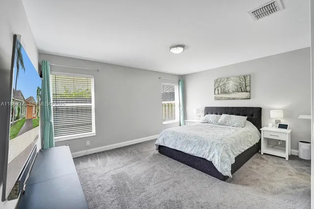 a spacious bedroom with a bed and a large window