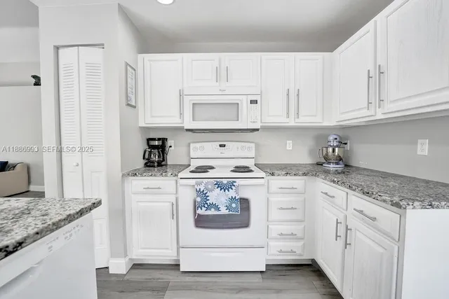 a kitchen with white cabinets and white appliances