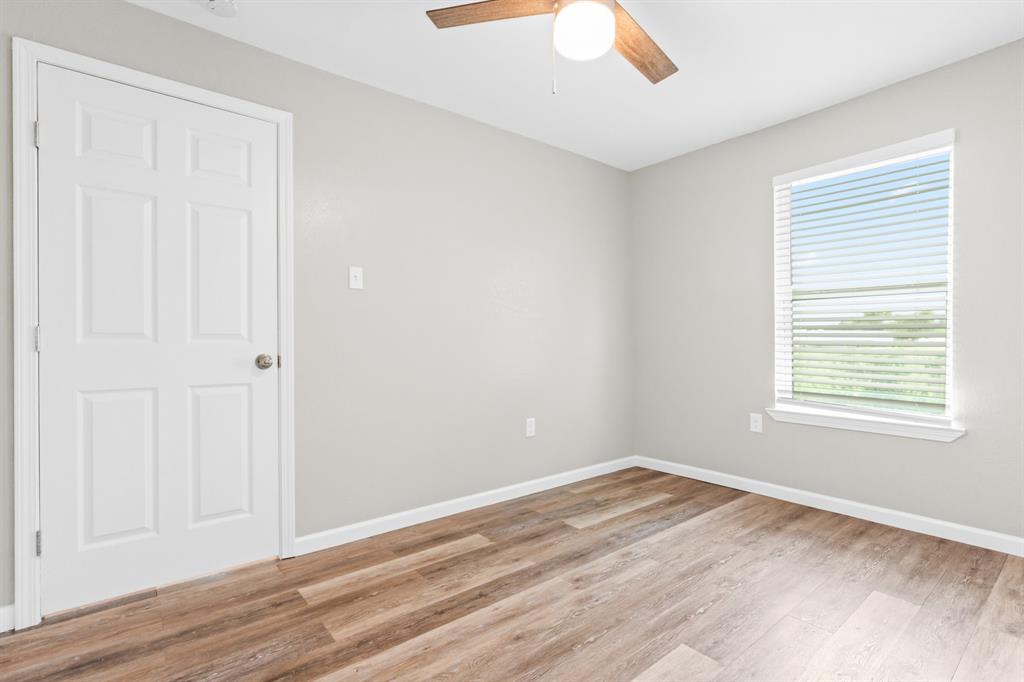 1210 Southey Street Waco, TX 76704 - Photo 14 of 29 an empty room with wooden floor and windows