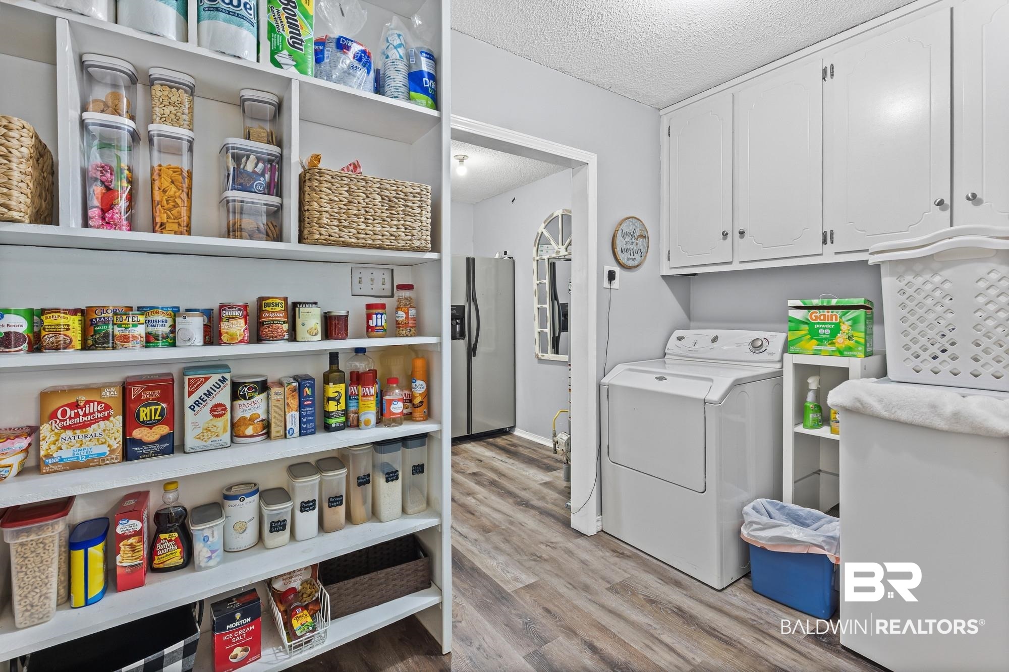 6609 Blakeley Court Mobile, AL 36695 - Photo 9 of 28 Laundry area with a textured ceiling, light wood-style floors, cabinet space, and separate washer and dryer