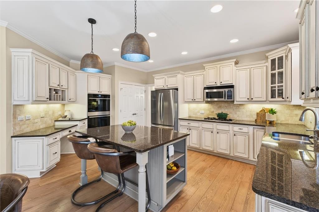248 Cedarhurst Drive Canton, GA 30115 - Photo 22 of 76 a kitchen with stainless steel appliances granite countertop a stove top oven a sink dishwasher a dining table and chairs with wooden floor