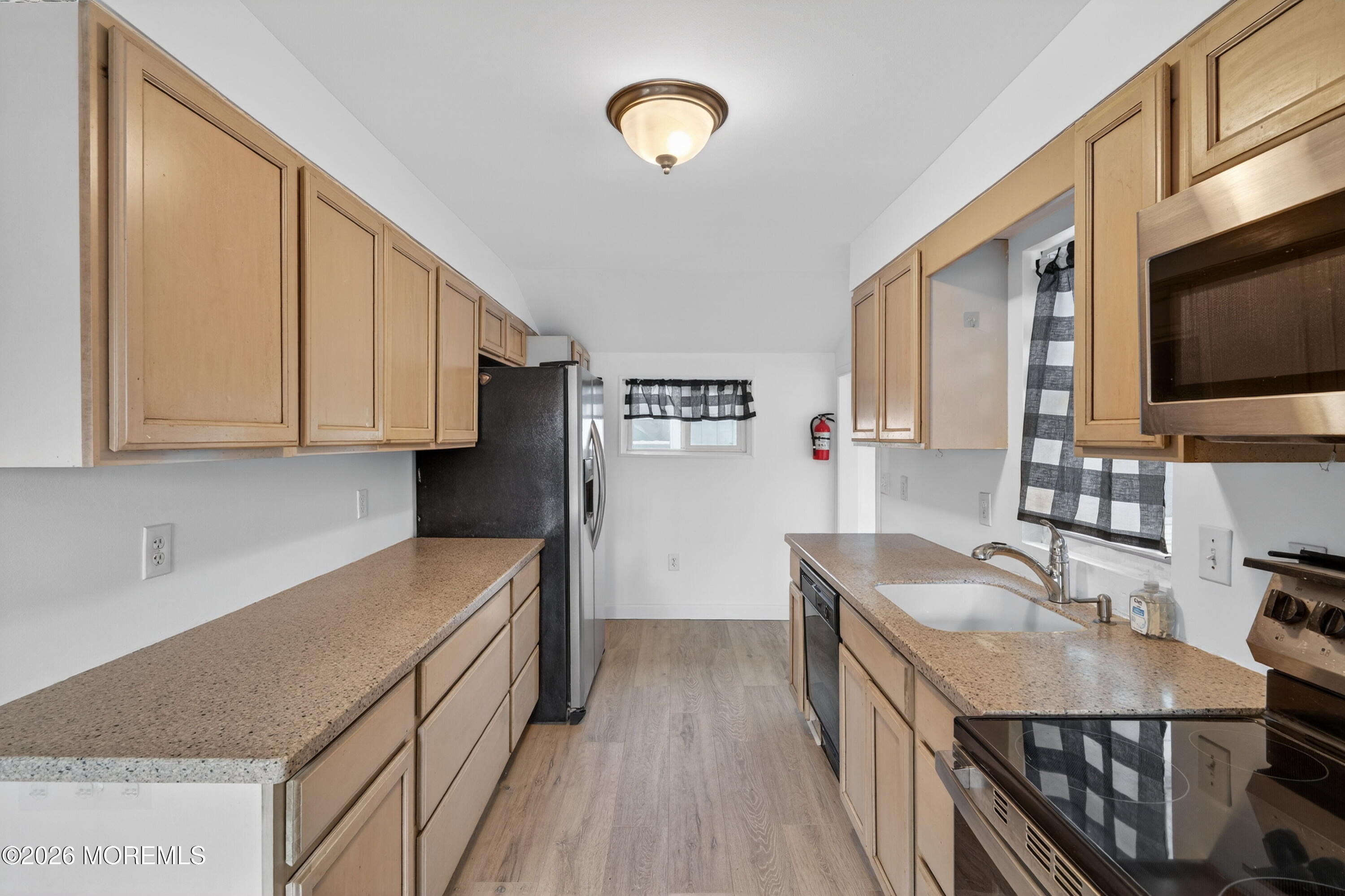 11 Cedar Road Brick, NJ 08723 - Photo 32 of 39 a kitchen with granite countertop a stove top oven a sink dishwasher and wooden cabinets with wooden floor