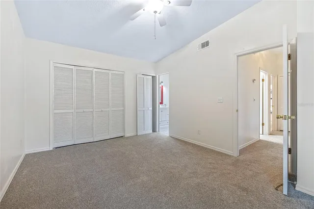 an empty room with chandelier fan