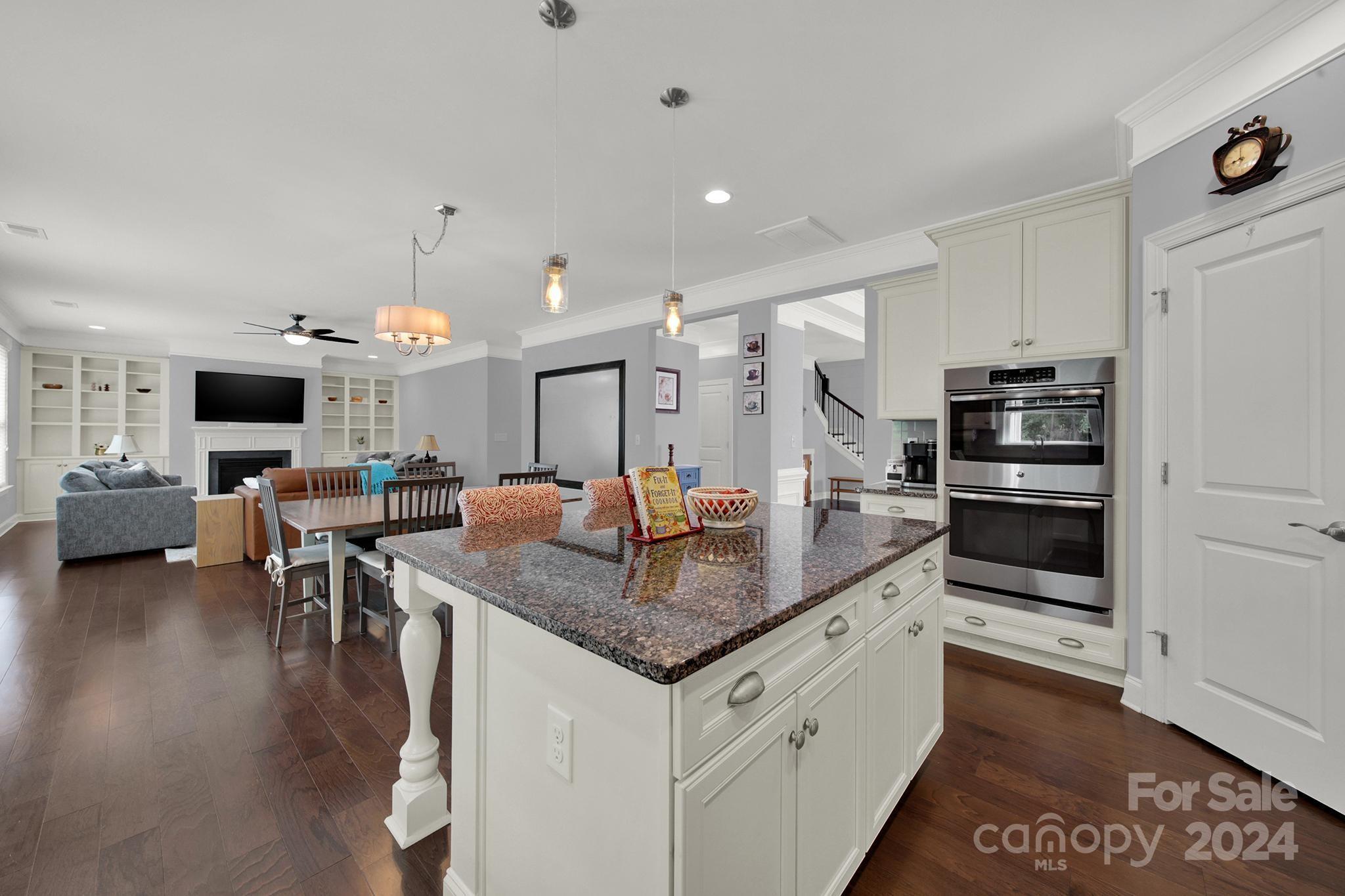 1826 Larkspur Way Tega Cay, SC 29708 - Photo 8 of 48 a kitchen with stainless steel appliances granite countertop a stove top oven a sink dishwasher and chairs with wooden floor