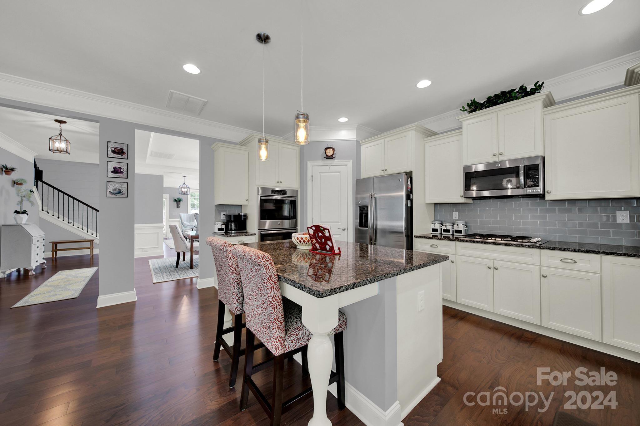 1826 Larkspur Way Tega Cay, SC 29708 - Photo 9 of 48 a large white kitchen with stainless steel appliances