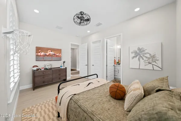 a spacious bedroom with a bed and a potted plant
