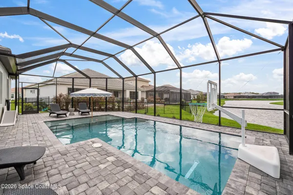 a view of a big yard with table and chairs plants and large trees