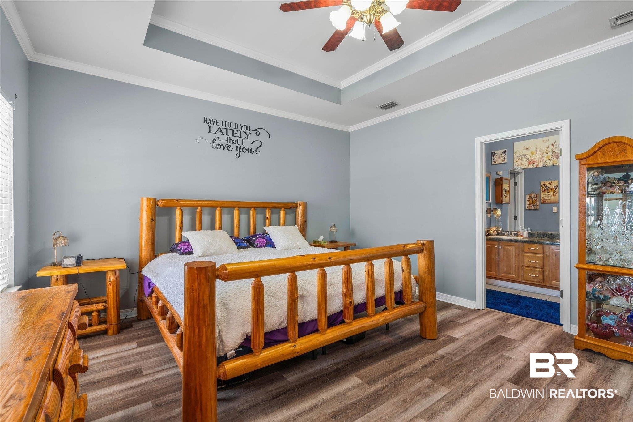 22095 Buck Road Robertsdale, AL 36567 - Photo 11 of 22 Bedroom with wood finished floors, a tray ceiling, a ceiling fan, crown molding, and ensuite bath