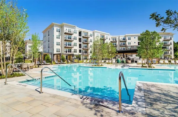 a front view of a house with a garden and fountain