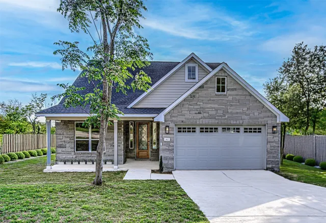 a front view of a house with a yard and potted plants