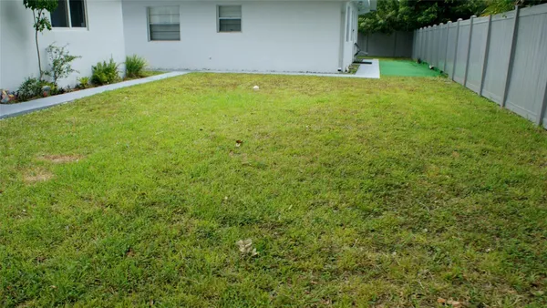 a view of yard with swimming pool and wooden fence