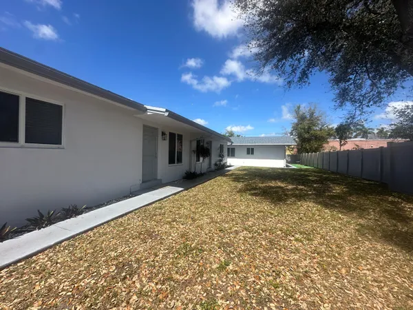 a view of house with backyard and tree