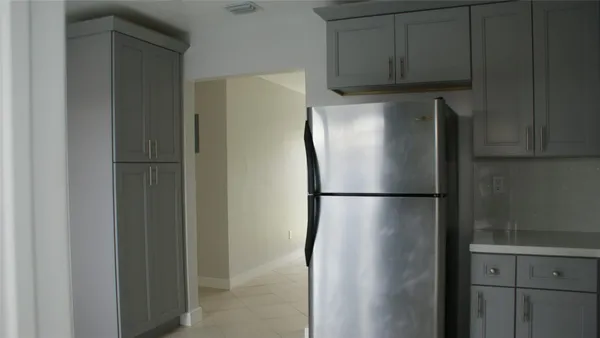 a view of a refrigerator in kitchen and cabinets