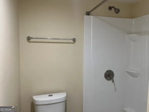 a bathroom with a toilet and a shower