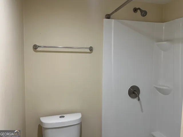 a bathroom with a toilet and a shower