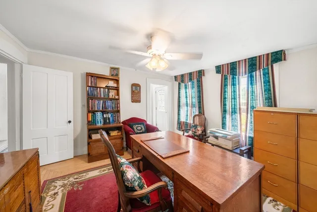 a living room with furniture a bookshelf and a window