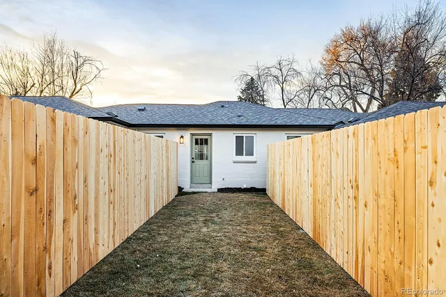 a view of a backyard with wooden fence