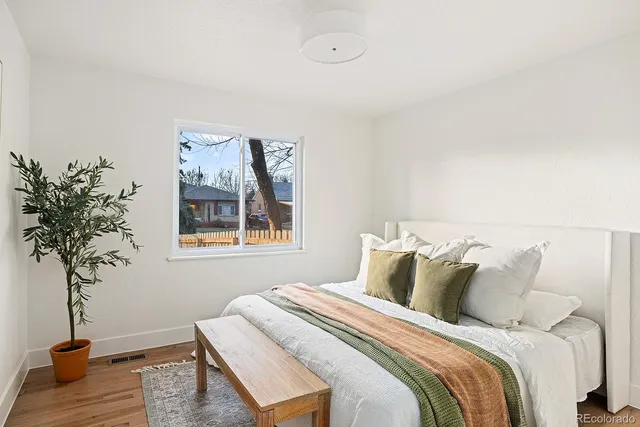 a bedroom with a bed and a potted plant