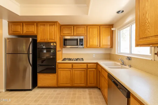 a kitchen with stainless steel appliances granite countertop a refrigerator a stove a sink and a microwave