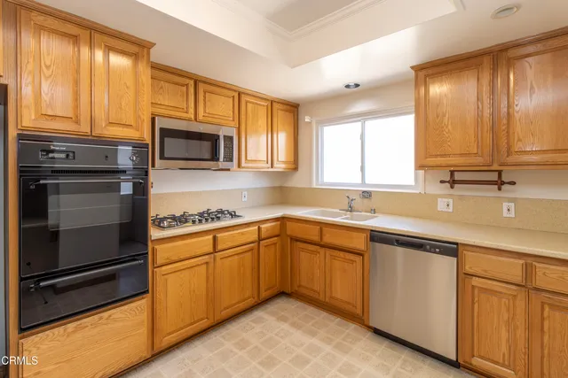 a kitchen with cabinets stainless steel appliances and window