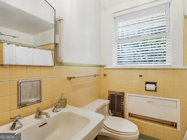 a bathroom with a sink a toilet and a mirror