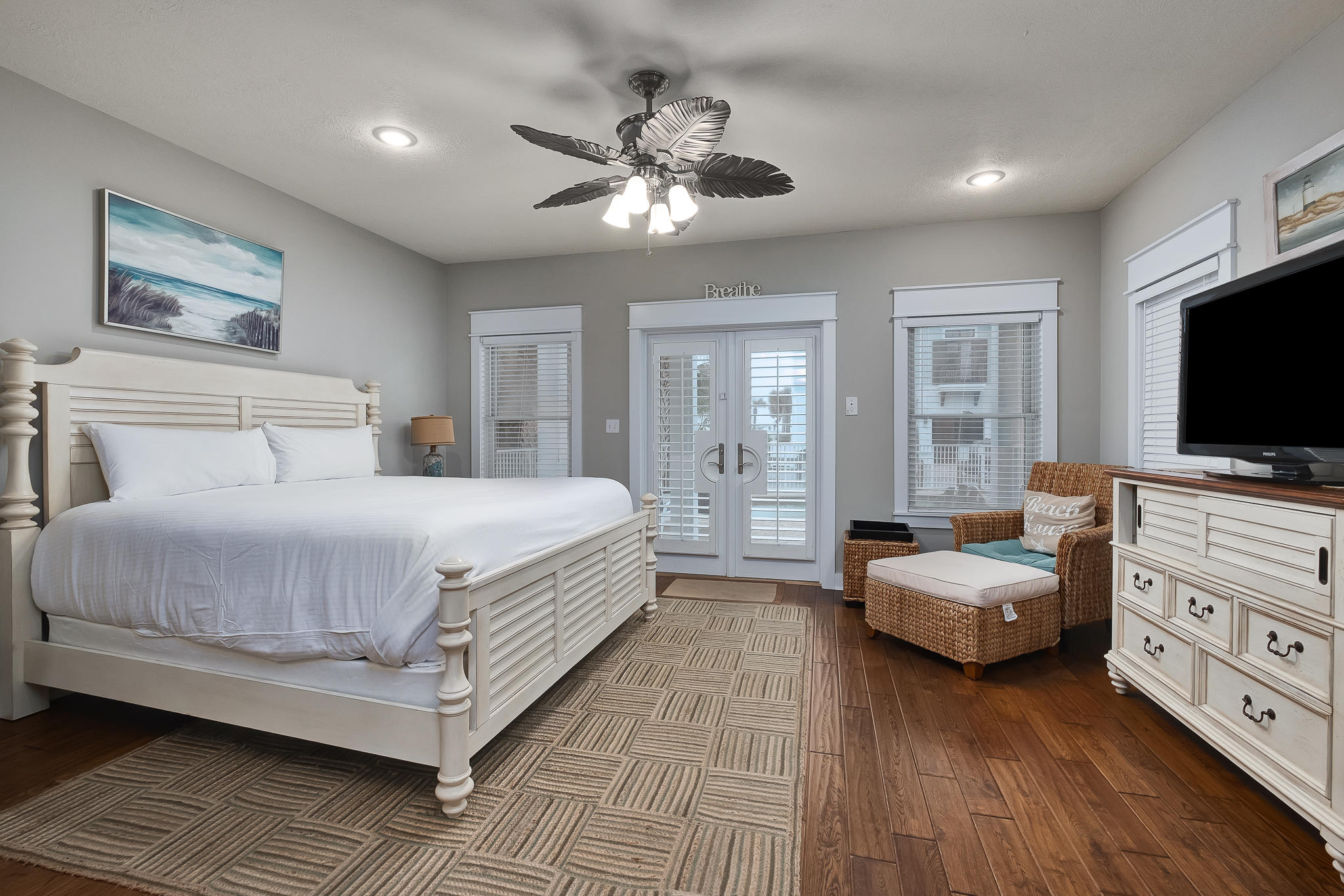 a bedroom with a bed and a flat tv screen on dresser