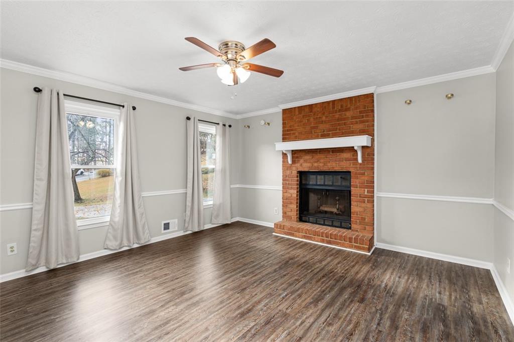 474 Daisy Trail Lawrenceville, GA 30046 - Photo 12 of 41 an empty room with windows fireplace and wooden floor