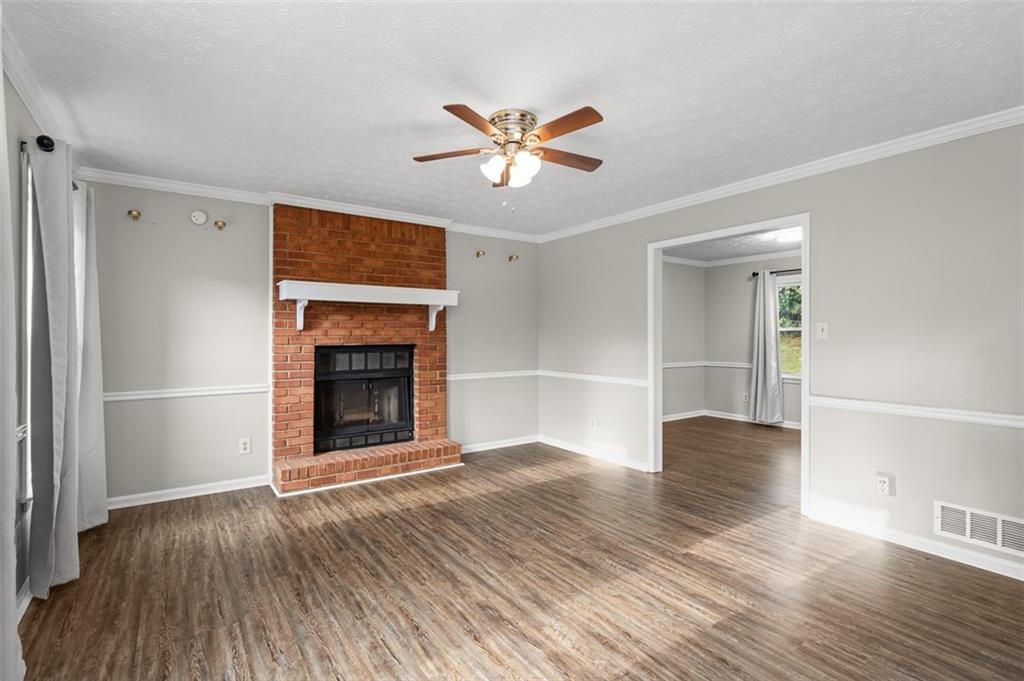 474 Daisy Trail Lawrenceville, GA 30046 - Photo 10 of 41 a view of an empty room with wooden floor fireplace and a window