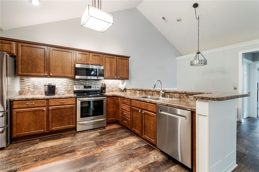 9151 Springfield Road, Unit 1902 Youngstown, OH 44514 - Photo 13 of 36 Kitchen with kitchen peninsula, backsplash, hanging light fixtures, dark wood-type flooring, and appliances with stainless steel finishes