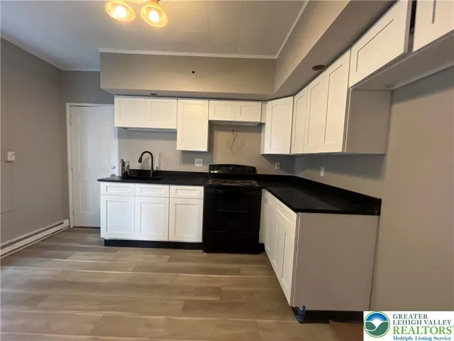 a kitchen with a sink a stove and cabinets