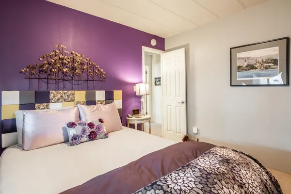 a bedroom with a bed and painting on the wall