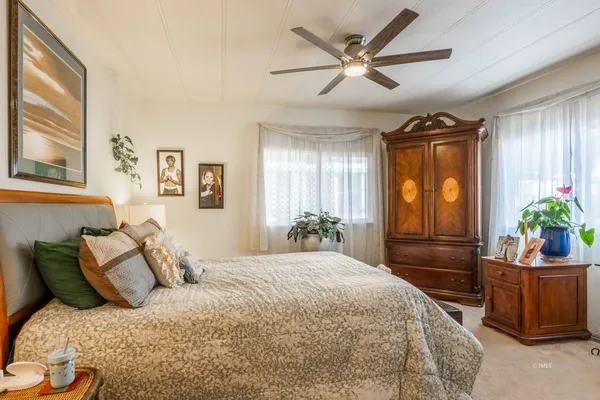 a bedroom with a bed and dresser with mirror