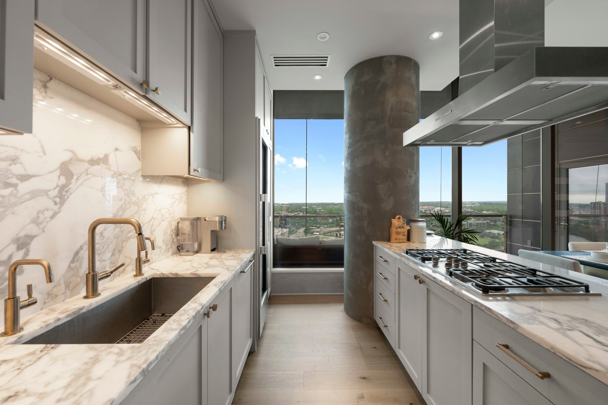 210 Lavaca Street, Unit 2706 Austin, TX 78701 - Photo 24 of 32 Modern kitchen featuring full-height windows, light wood-finish flooring, and light gray cabinetry