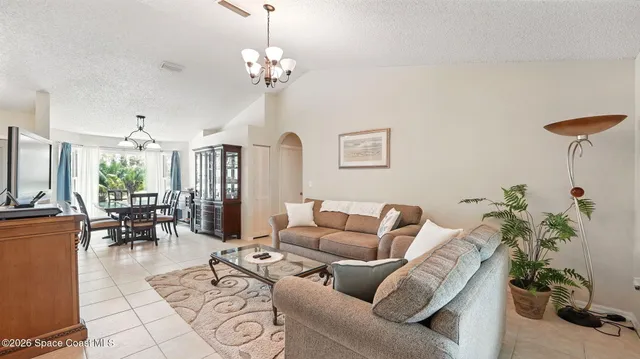 a view of a dining room and livingroom with furniture wooden floor a chandelier