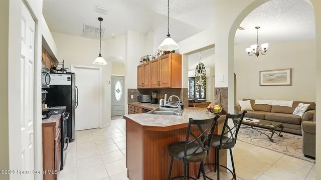 a kitchen with stainless steel appliances granite countertop a stove a sink dishwasher and a microwave oven with large cabinets