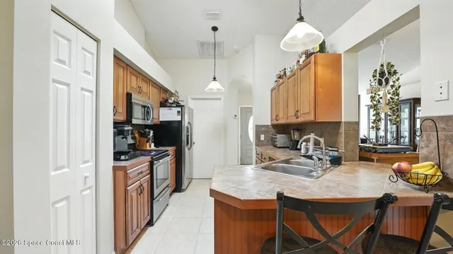 a kitchen with stainless steel appliances a refrigerator sink and stove